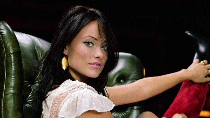 Olivia Wilde Sitting On Sofa And Pink Lips Looking At Camera